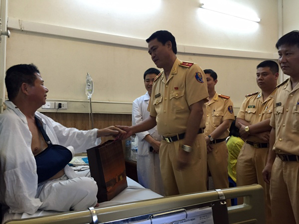 Thiếu tướng Nguyễn Hữu Dánh, Cục phó Cục CSGT tặng quà, động viên Trung tá Phạm Văn Tuyến.